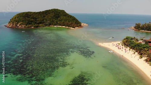 Aerial drone view small Koh Ma island, Ko Phangan Thailand. Exotic coast panoramic landscape, Mae Haad beach, summer day. Sandy path between corals. Vivid seascape, mountain coconut palms from above. photo