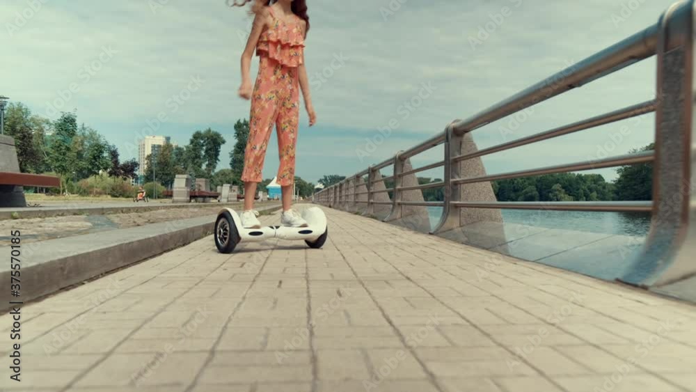 A beautiful young girl skates quickly and makes a U-turn on the spot. Active type of rest. Rest on a day off in the park outside.