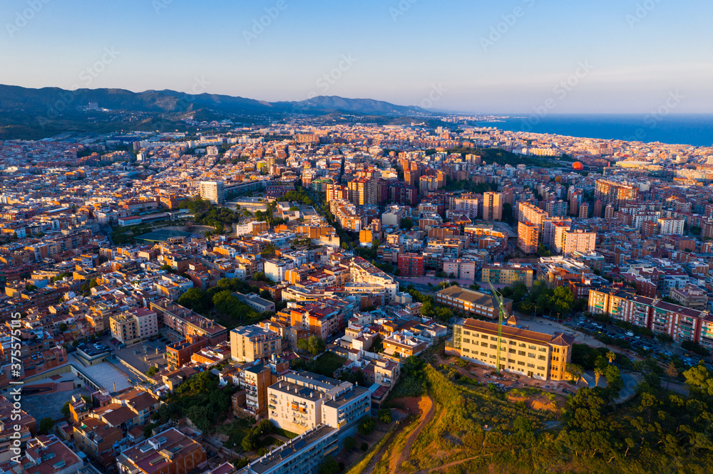 Aerial panoramic view of Sant Adria de Besos and Badalona with Mediterranean sea and Sierra de la Marina mountains in background on sunny day, Spain