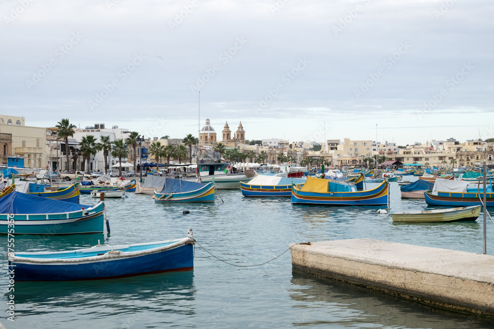 The traditional maltese luzzu boats in the harbor of fishing village Marsaxlokk in Malta 