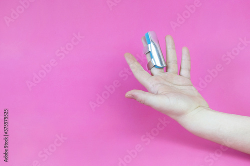Blue aluminum finger splint with locks on the broken middle finger. Copy space - concept of injury, hand injury, treatment, body, operation, rehabilitation