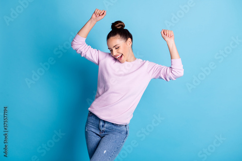 Photo of positive cheerful girl enjoy rejoice dance night club raise fists wear good look mood pullover isolated over blue color background