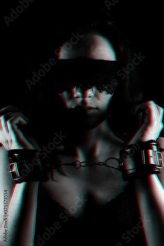 portrait of a female slave with a bandage on his face and leather handcuffs BDSM sex and role-playing games on hand