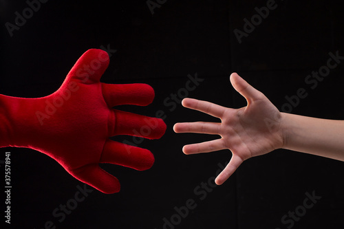 Hand reaching out for help, young boy playing with plush soft toy, handshake with imaginary friend photo