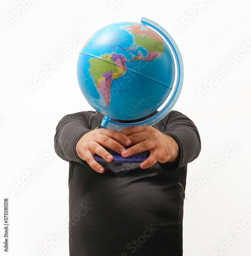 Man wearing black dress with a globe in front of his head. A male in dark shirt and holding globe in front of his face. Business, education and idea concept.  no face. global thinking photo