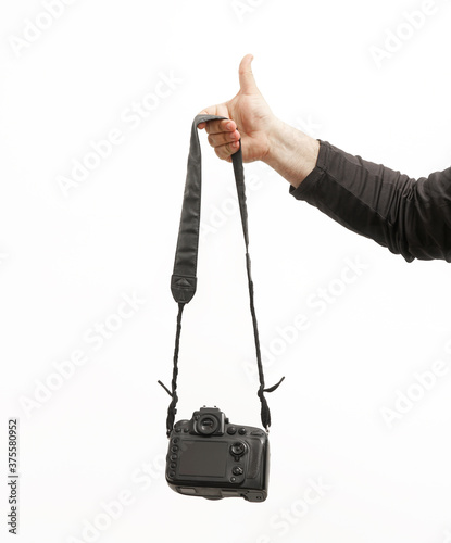 thumb up. isolated on white background. SLR digital camera in male hand. empty black  screen. DSLR camera back sibe in arm. photo