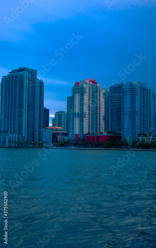 View of buildings in Brickell Miami, Florida as night time nears, High rises near water in Miami, Cold look of buildings, Cold look of high rises, Cold look of buildings near water, Nighttime in city © Shaheem