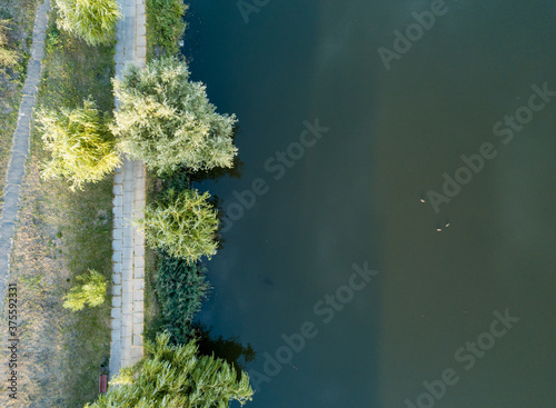 Aerial drone view. Walking paths near the lake in the city park of Kiev.