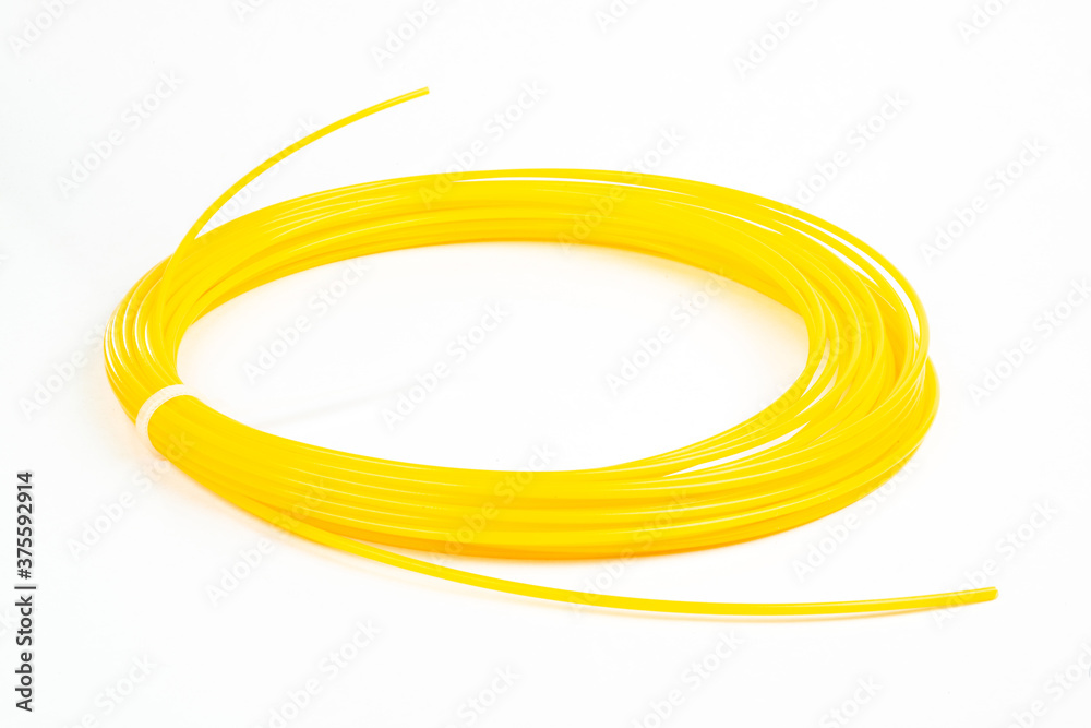 Top view of yellow rolled filament plastic for 3D Printing Pen isolated on white. Top view of yellow rolled filament plastic for 3D Printing Pen isolated on white.