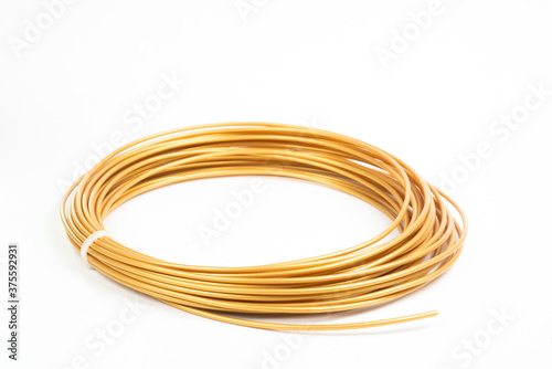 Top view of golden rolled filament plastic for 3D Printing Pen isolated on white.