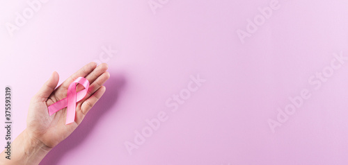 Hands holding pink ribbons  Breast cancer awareness  symbolic bow color raising awareness on women s breast tumor. Healthcare  medicine and breast cancer awareness concept.