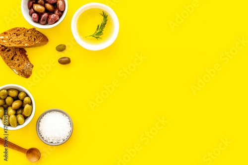 Mediterranean olives near bread on cutting board top view copy space