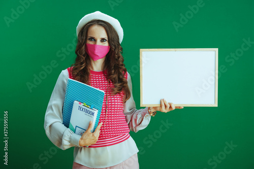 elegant female showing blank board against green background