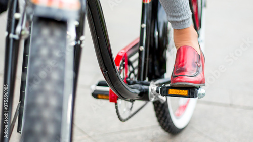 woman on retro bike, focus on legs, red shoes