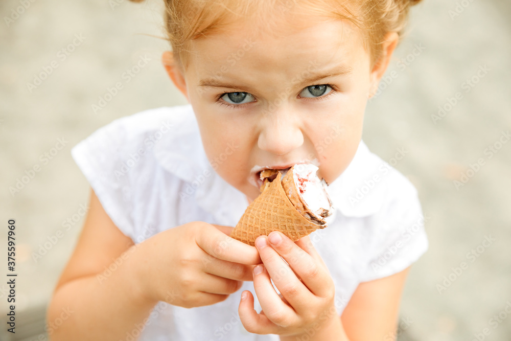 Annoyed blonde girl eats vanilla ice cream in a waffle Annoyed blonde girl eats vanilla ice cream in a waffle