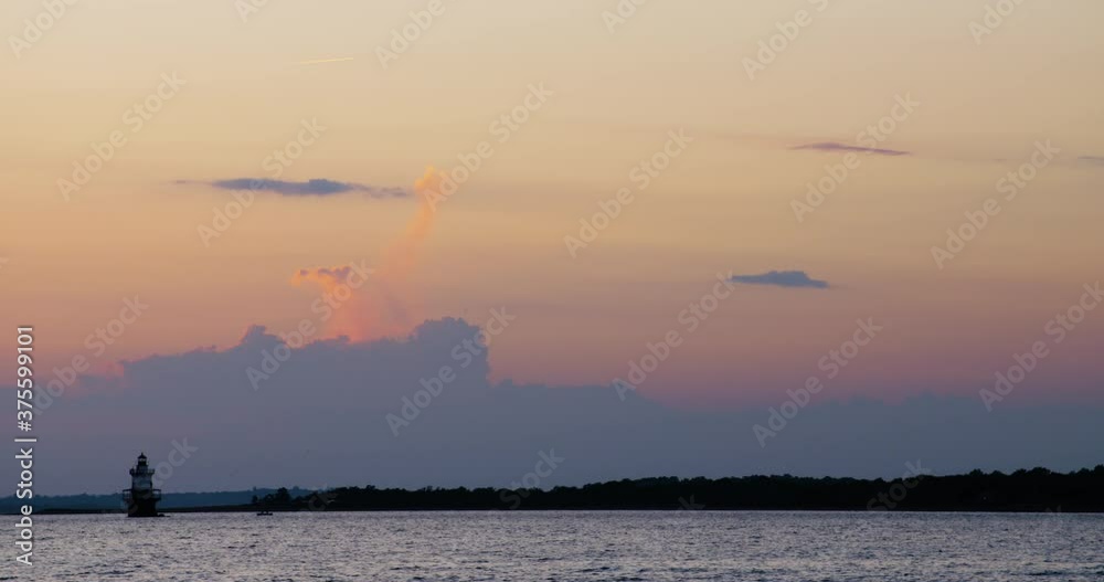 Dramatic Sky And Lighthouse Over Ocean After Sunset