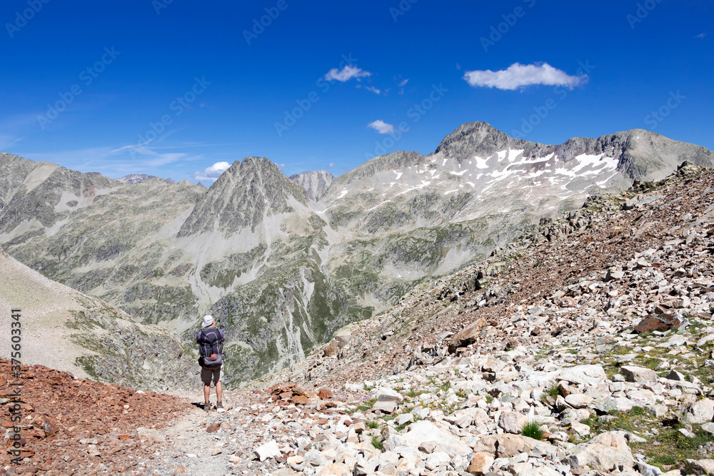 Man hiking in mountains. Hiking in Pyrenees National Park, Hautes-Pyrenees, Occitanie in south of France France Man hiking in mountains. Hiking in Pyrenees National Park, Hautes-Pyrenees, Occitanie in south of France France