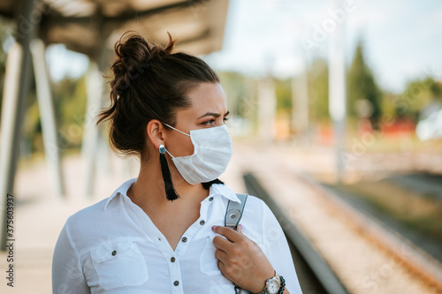 Corona virus lifestyle concept of a young women in city street who walks with surgical or protecting mask during pandemic.