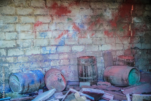 bright colorful multicolored solid background: with multicolored paints after the Holi festival, for design. red, blue, yellow, green paint on brick wall. old wooden barrels photo