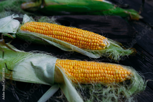 Foto Yellow corn on the cob on a wooden table