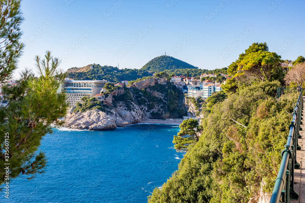 Adriatic Sea view, Dubrovnik. Sunny winter day view, Croatia. Blue sea water, cacti and other trees and bushes at the high shore. Travel photography.
