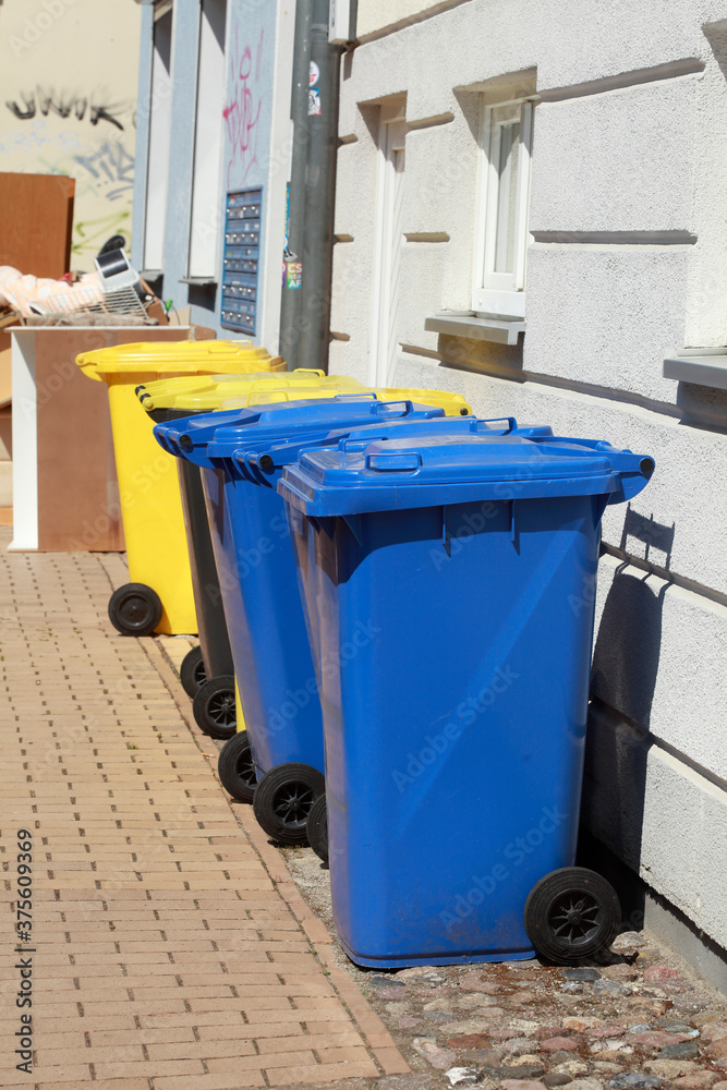 Bunte verschiedene Wertstofftonnen, vor einem Wohnhaus auf der Straße stehend, Deutschland Bunte verschiedene Wertstofftonnen, vor einem Wohnhaus auf der Straße stehend, Deutschland