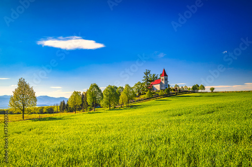 Rural landscape with a church in the background. Saint Kosmas Church in Abramova village, Turiec Region, Slovakia, Europe. photo