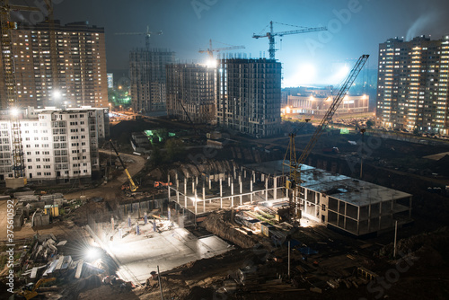 Construction site with crane columns at night © ilyaska