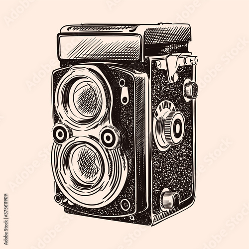 Old vintage camera with two lenses isolated on a beige background.