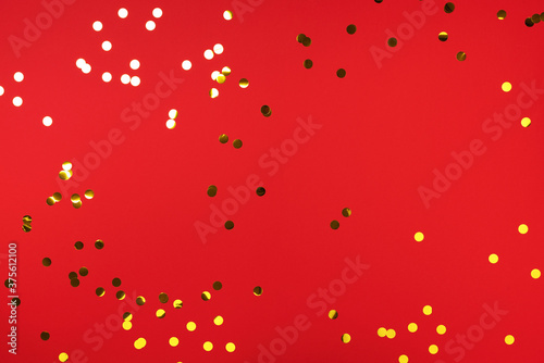 Golden confetti on red background. Happy new year celebration party. Greetings and congratulation concept. Festive backdrop with copy space for your design
