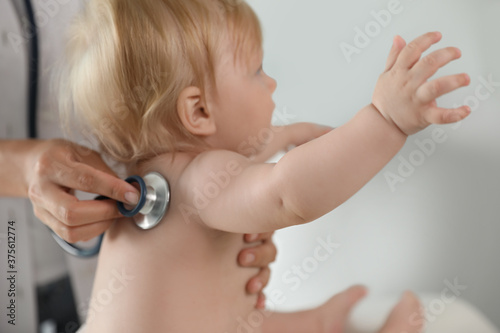 Pediatrician examining baby with stethoscope in hospital, closeup. Health care