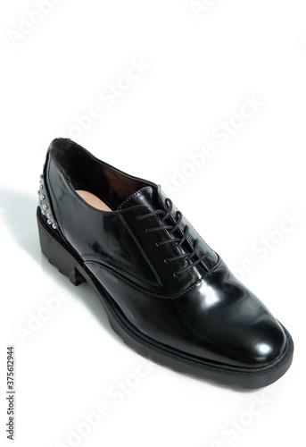 Fashionable female black leather shoes with silver details isolated on a white background.