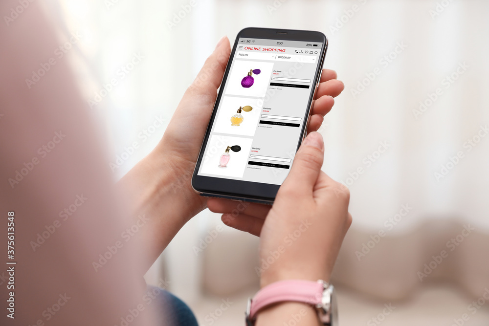 Woman shopping online using smartphone indoors, closeup