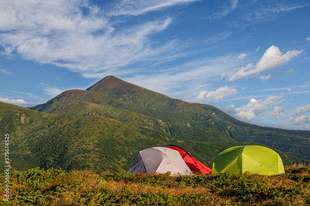 Three tents stand on a slope under Hoverla in the Carpathian mountains in Ukraine