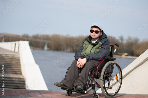 A man wearing sunglasses in a wheelchair for a walk