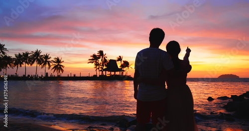 couple stand on sunset beach