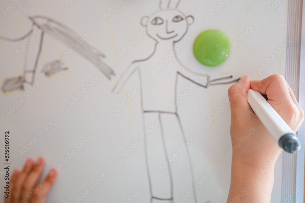 Obraz premium Little girl is writing on the white board