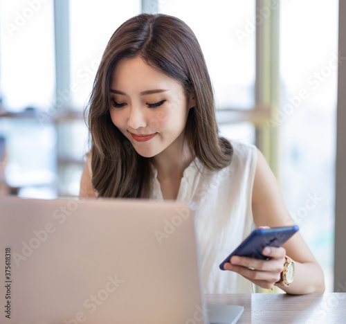 woman use smartphone and laptop
