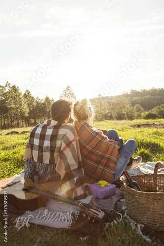 Couple enjoys a day of picnics. They are on their backs looking at the sunshine. Concept of love and Valentine's Day.