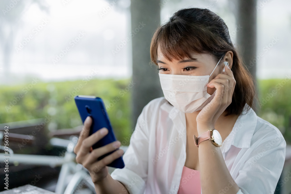 woman wears earbud use smartphone woman wears earbud use smartphone