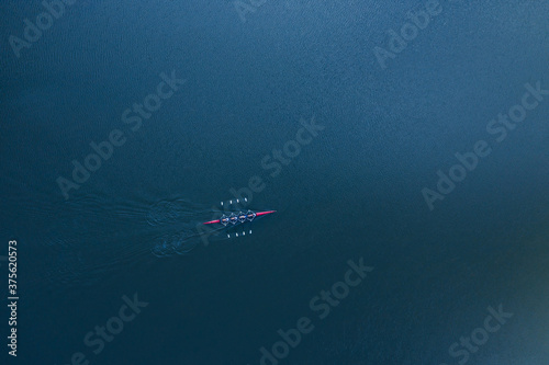 Canvastavla Boat coxed four rowers rowing on the blue river aerial drone top view