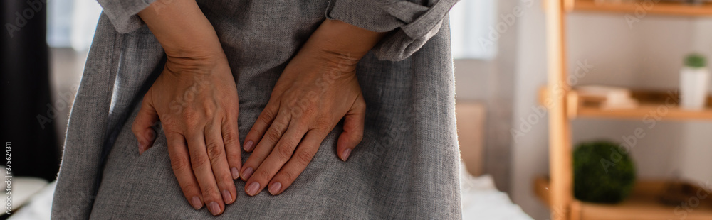 panoramic crop of woman suffering from back pain at home panoramic crop of woman suffering from back pain at home