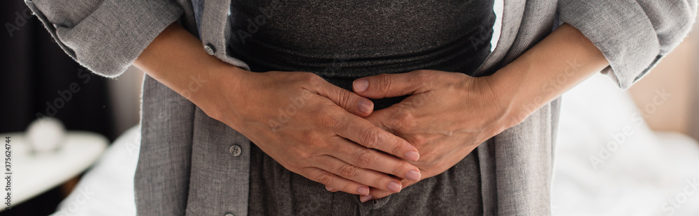 horizontal crop of woman having stomach ache at home horizontal crop of woman having stomach ache at home