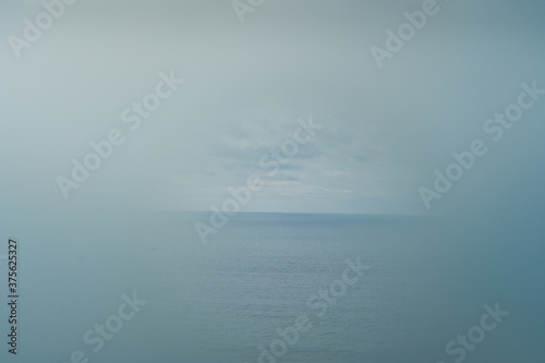 Foggy blurry weather and clear sea spot natural background. © aquar