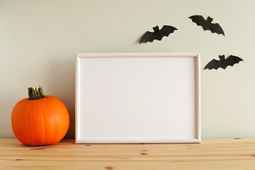 Horizontal white frame mockup, Halloween decorations, pumpkin, blank wooden frame.