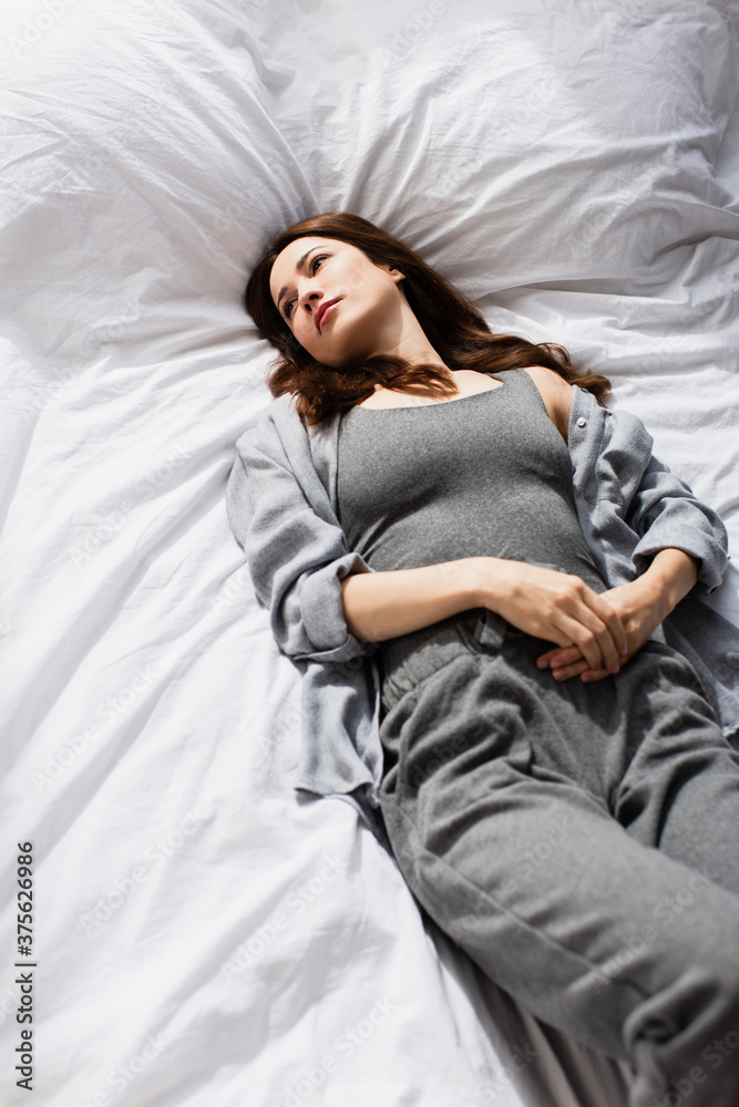 high angle view of depressed woman lying on bed high angle view of depressed woman lying on bed