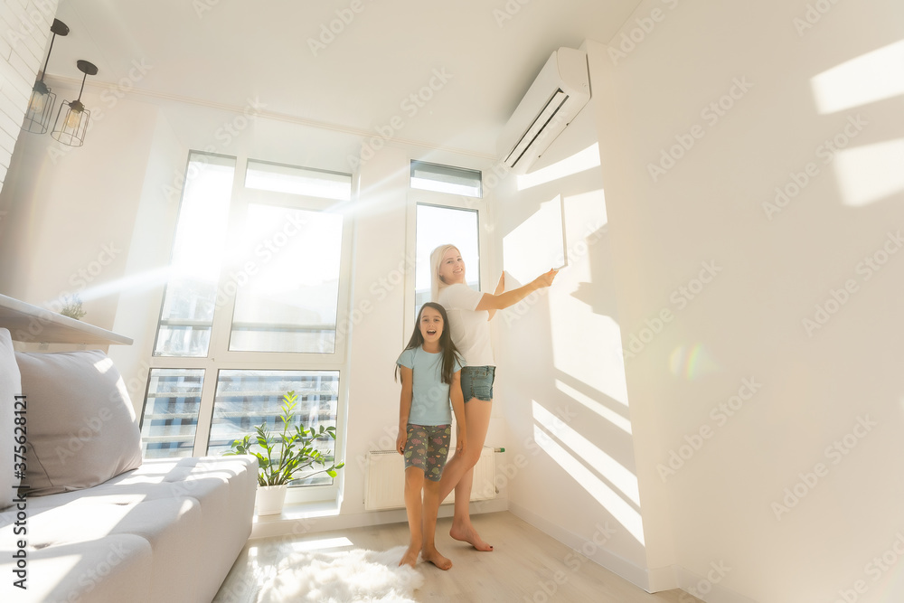 Fototapeta premium mother and daughter hangs a large photo canvas at home