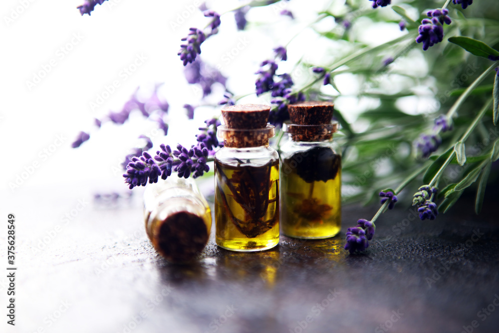 lavender oil in a glass bottle on a background of fresh flowers. lavender oil in a glass bottle on a background of fresh flowers.