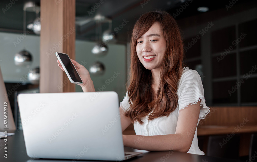 A beautiful Asian woman is using a laptop to communicate with business partners far away. To reduce travel times, work at home ideas A beautiful Asian woman is using a laptop to communicate with business partners far away. To reduce travel times, work at home ideas