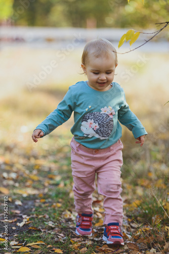 Adorable girl having fun on beautiful autumn day. authentic childhood image.
